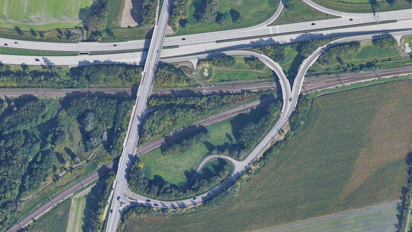Eine Luftaufnahme von verschiedenen Straßen und Straßenüberführungen unter denen Gleise hindurch führen.